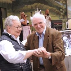 Zwei ältere Menschen tanzen draußen miteinander