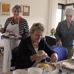 Drei Seniorinnen an einem Tisch mit Speisen